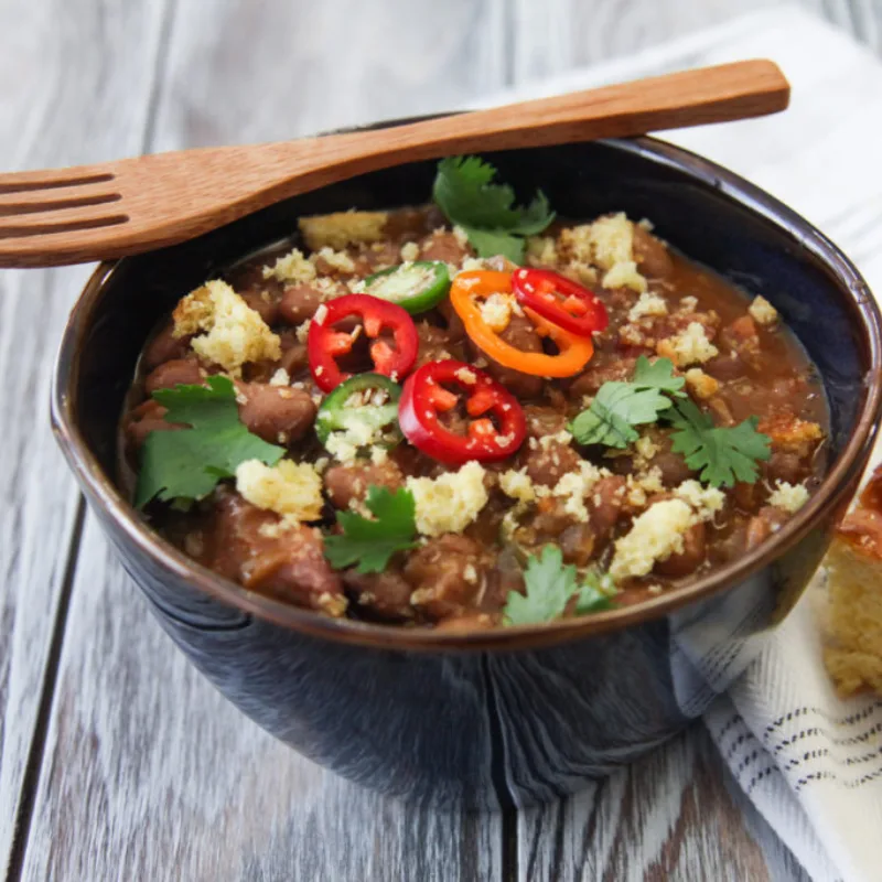Borracho Beans in a bowl with toppings, made with Carroll Shelby's Original Texas Seasoning.